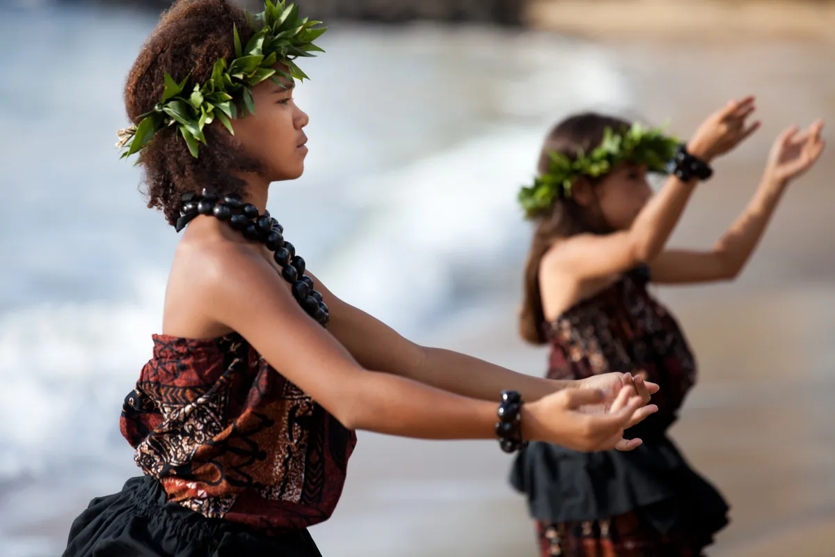 Hawaiian hula dancers performing traditional dance with lei and cultural dress
