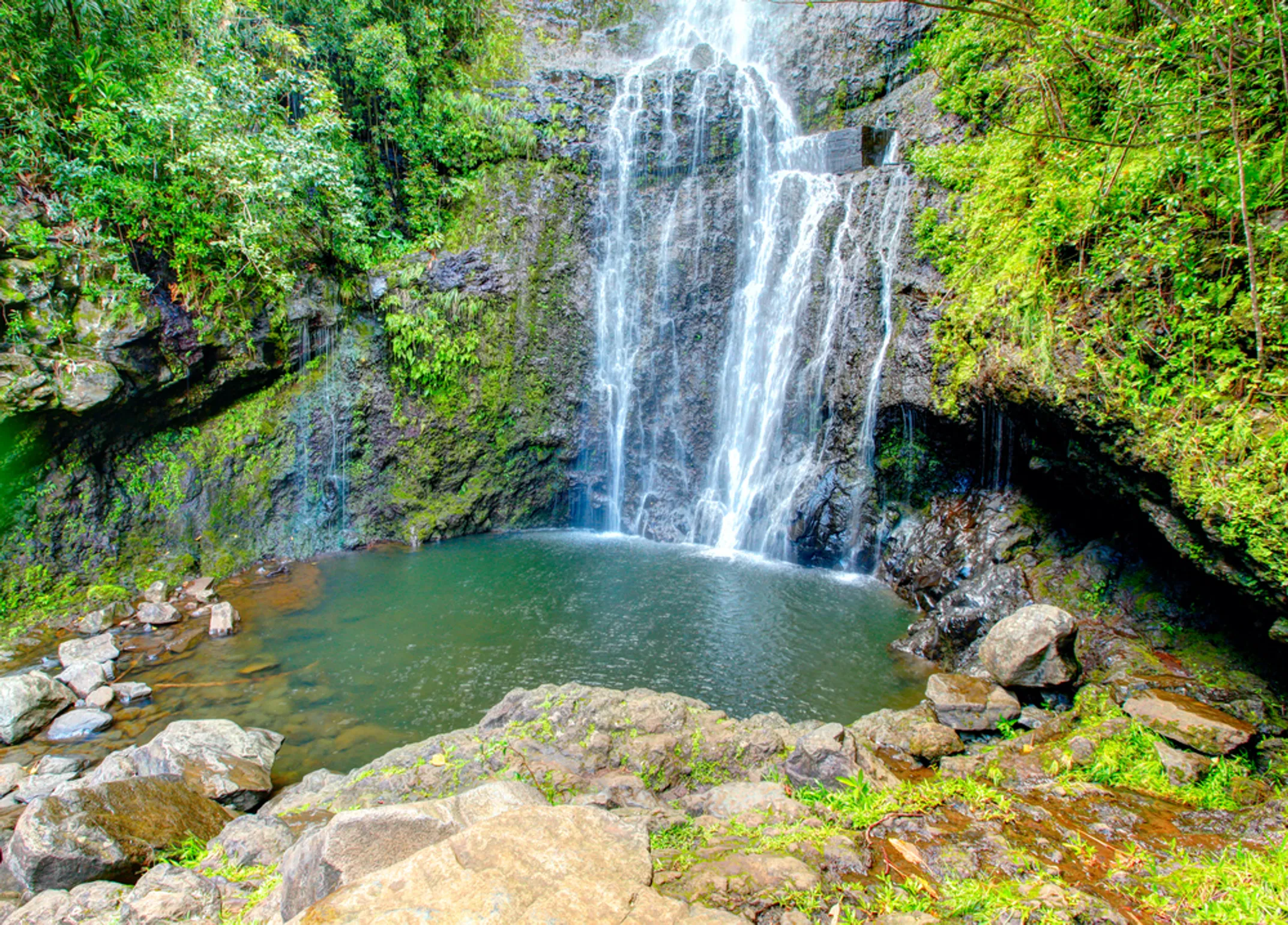 Stunning waterfall cascading into pools at Kīpahulu, Maui with lush tropical vegetation