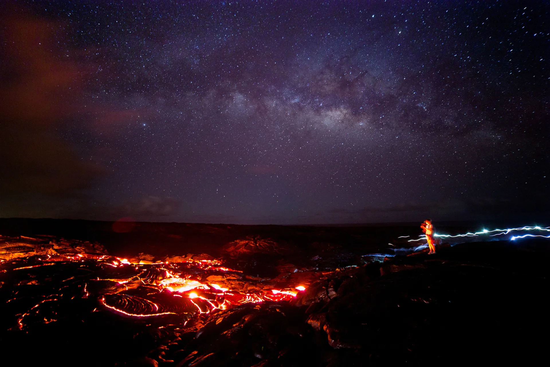 Spectacular stargazing scene at Volcanoes National Park with lava glow and Milky Way