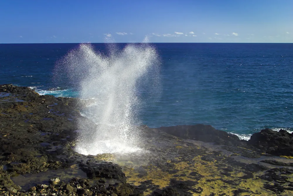 Photographer capturing Spouting Horn at golden hour