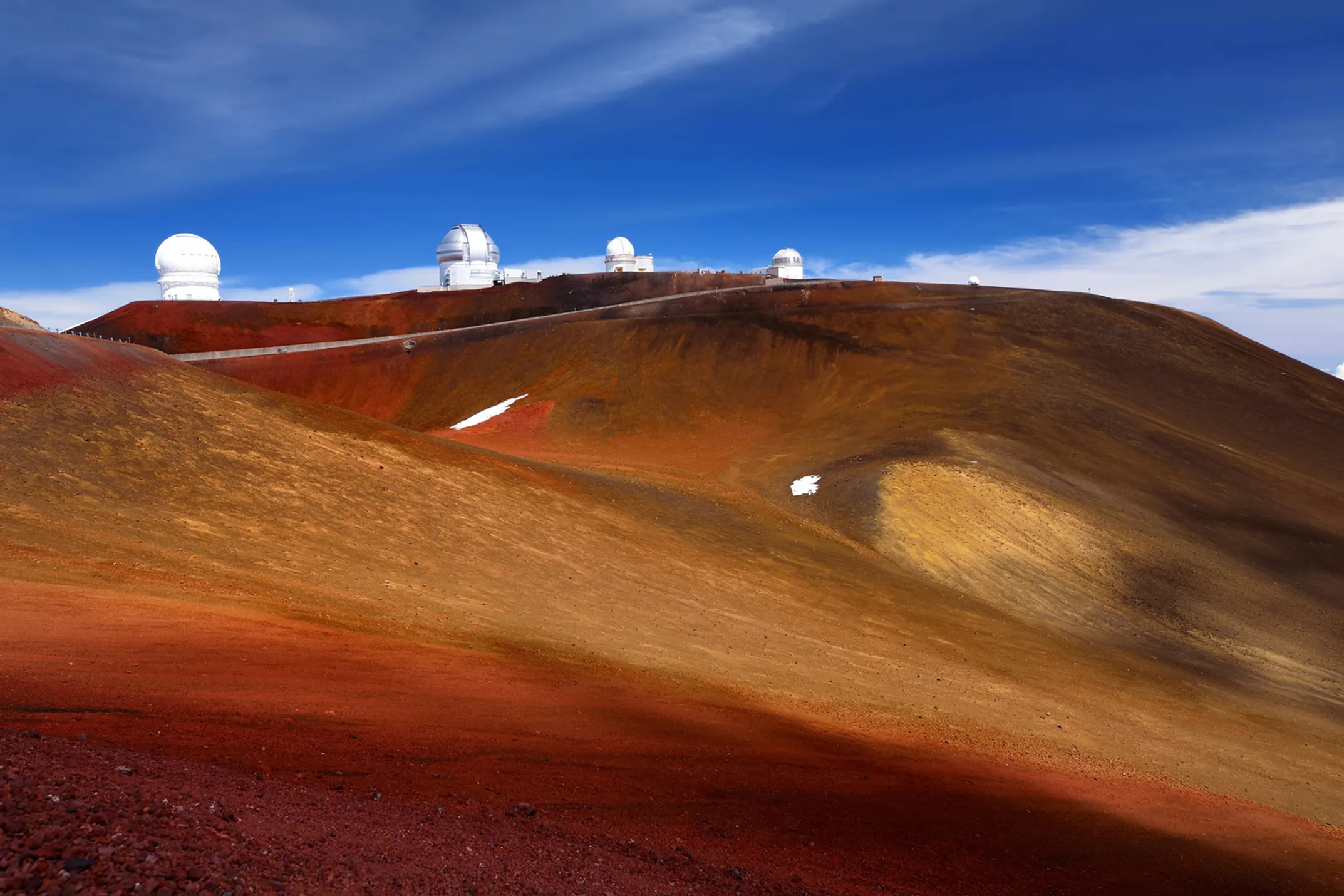 4WD vehicle on Maunakea access road with dramatic mountain landscape