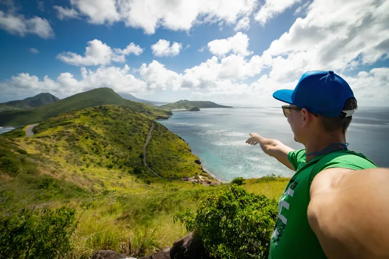A knowledgeable tour guide sharing stories with engaged travelers at a scenic Hawaiian overlook