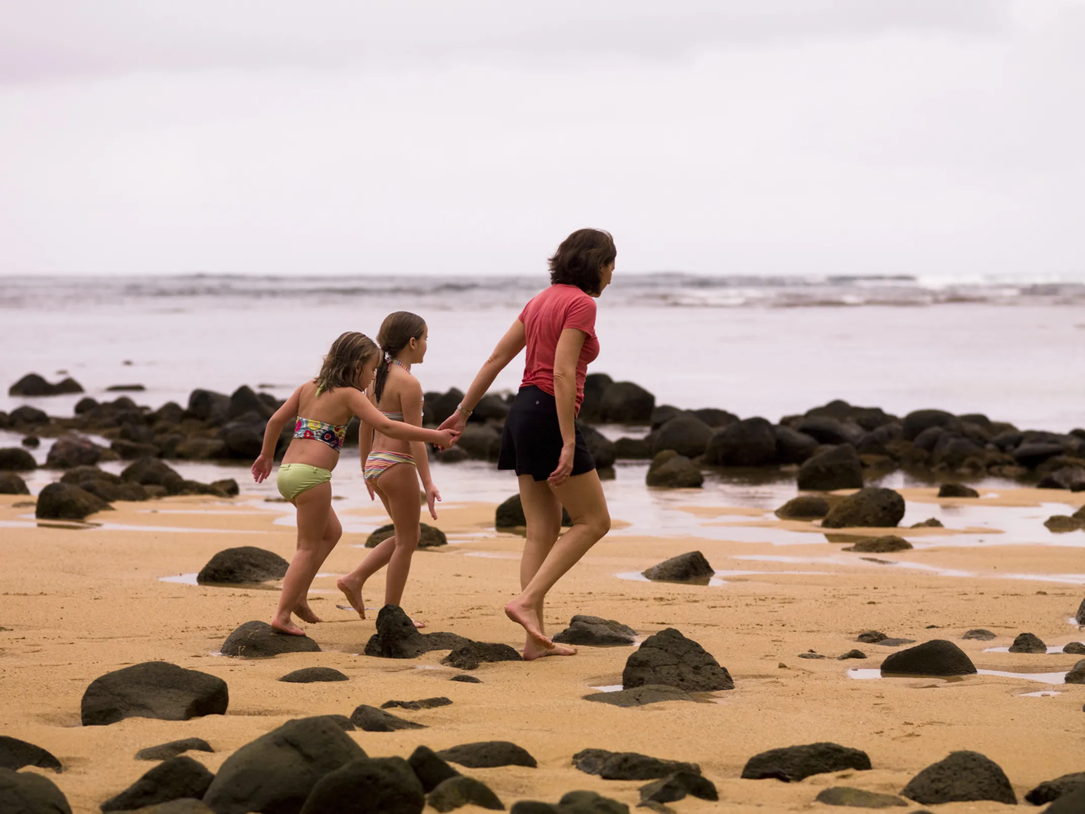 Family enjoying beautiful Maui beach with children playing safely in shallow water
