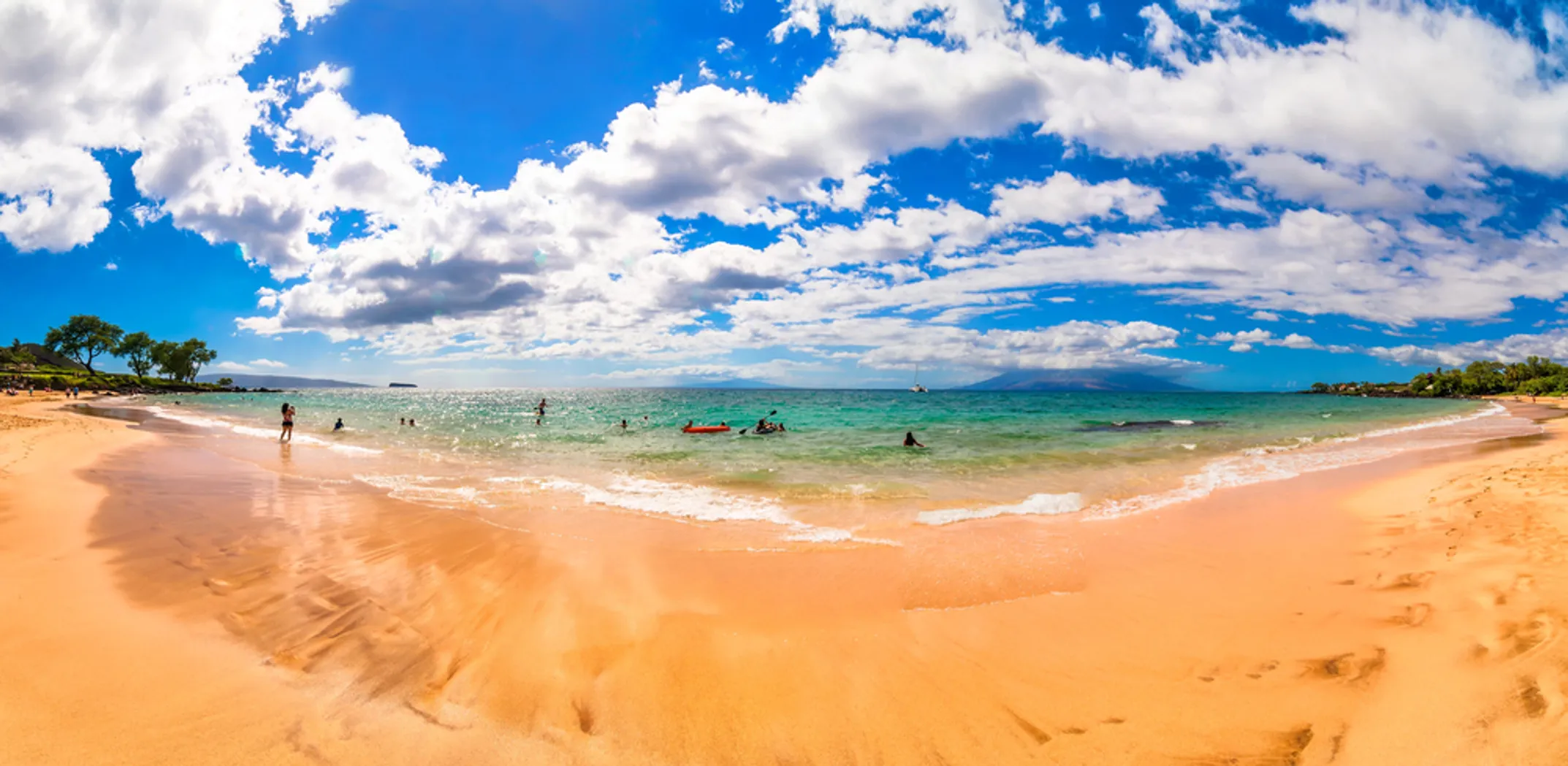 Secret Cove at Mākena with lava rocks, palm trees and turquoise water
