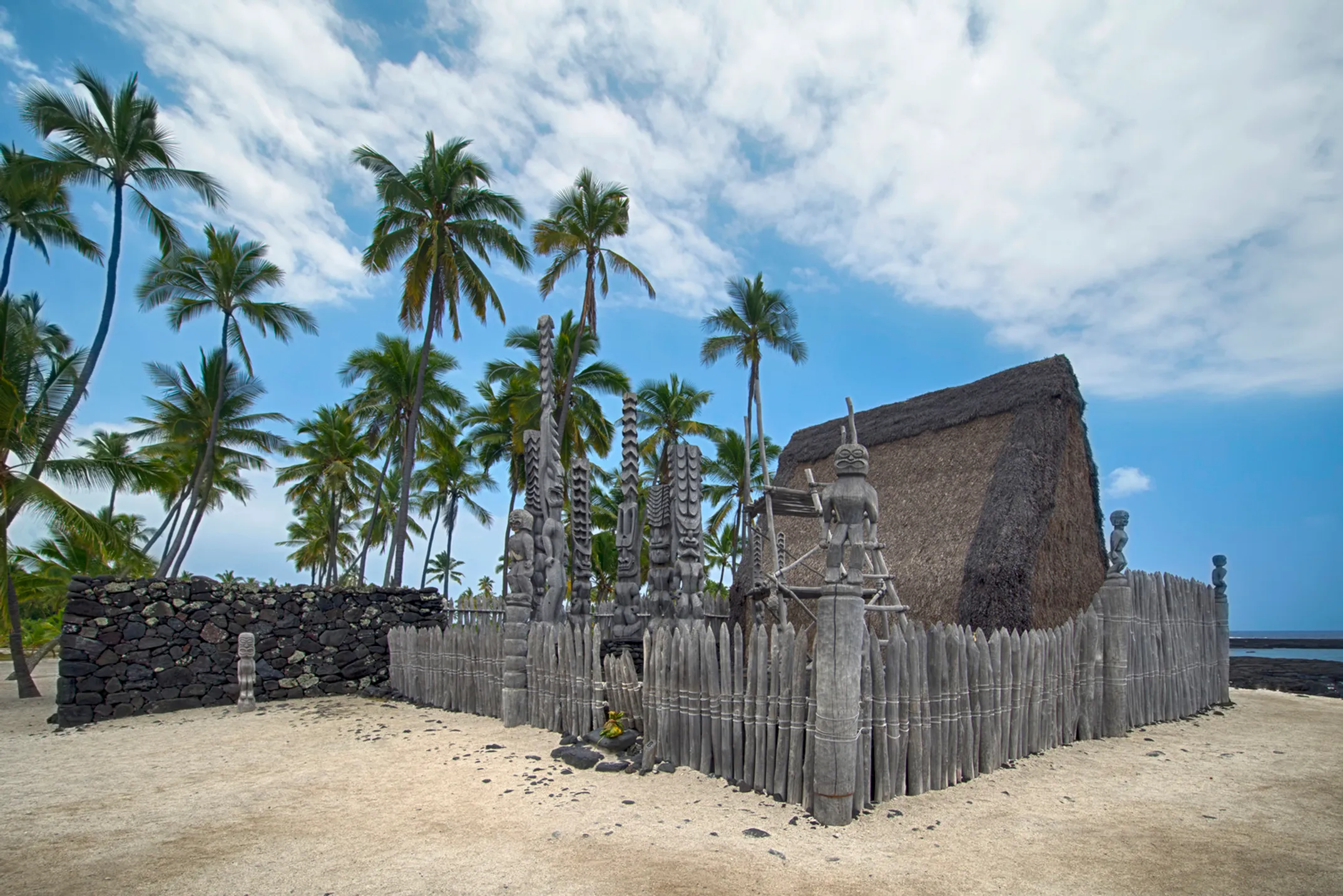 Traditional Hawaiian temple grounds at Puʻuhonua o Hōnaunau with kiʻi statues and sacred structures