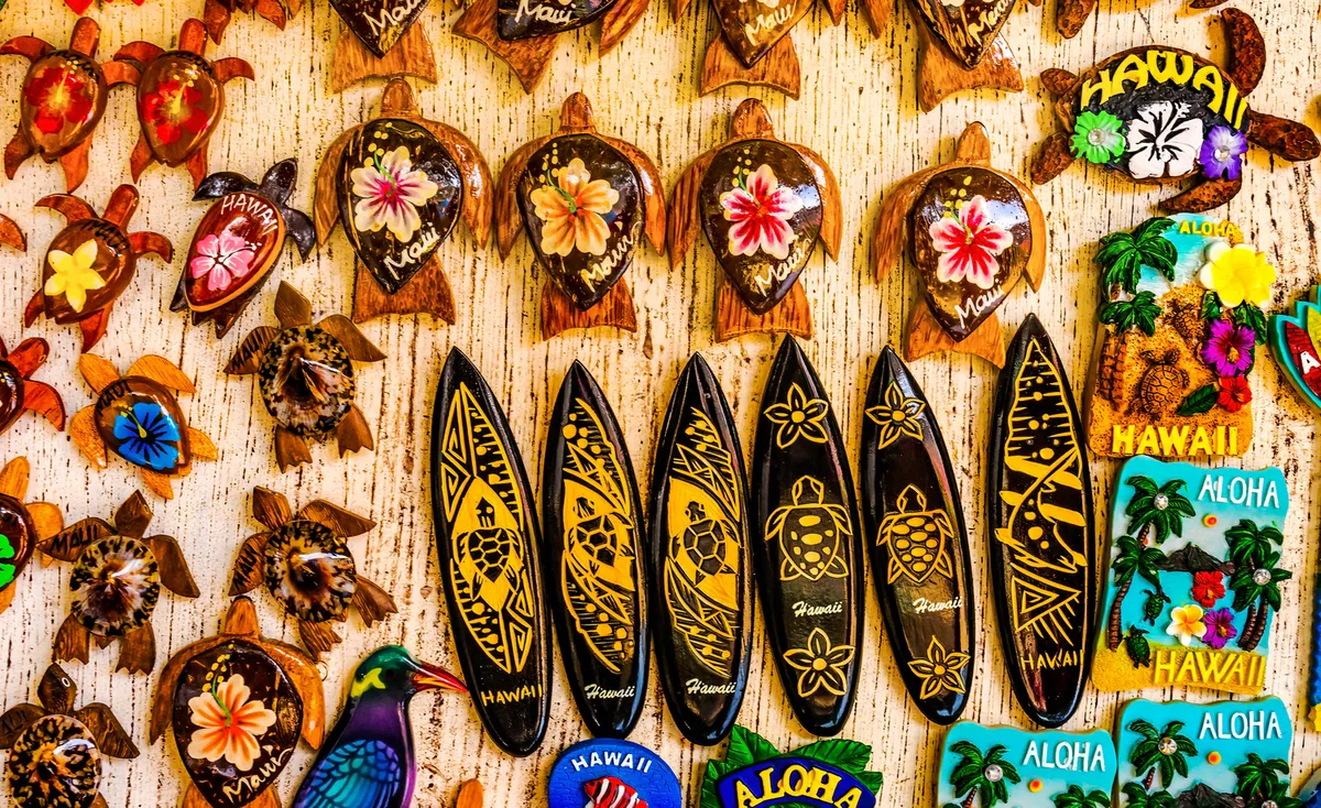Colorful display of fresh tropical fruits and local crafts at Hilo Farmers Market, with vendors and visitors browsing under canopy tents
