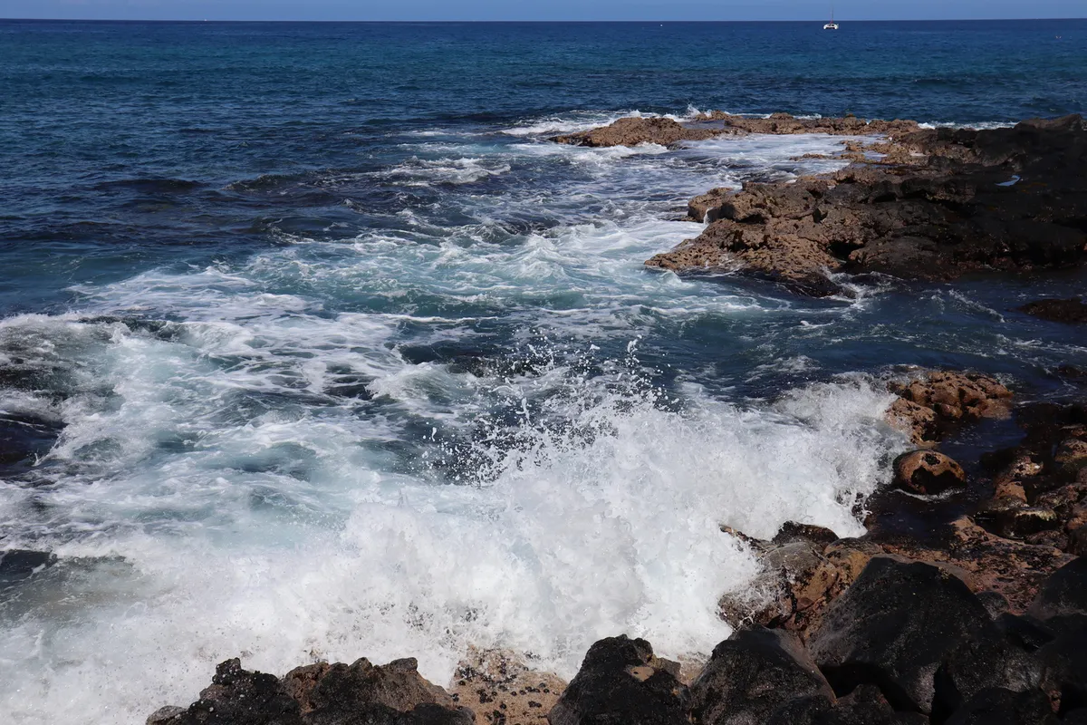 Dramatic coastline view of Keauhou Bay with crystal clear turquoise waters and black lava rock formations