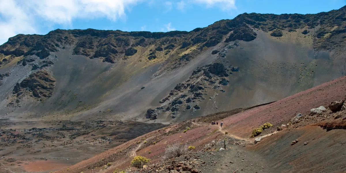 Panoramic view of Hawaii's diverse hiking landscapes showing lush valleys, volcanic peaks, and ocean coastlines from a mountain summit perspective