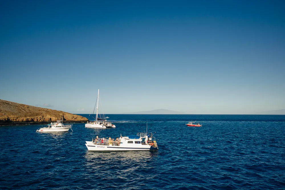 Boats anchored in beautiful Maui waters with Molokini Crater