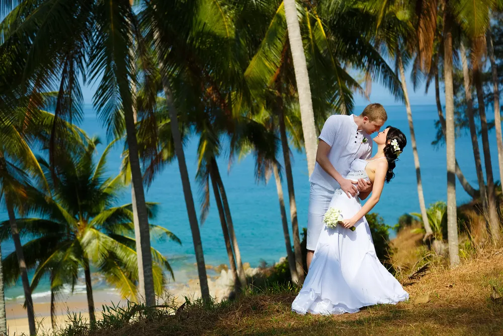 Beautiful Kauai beach wedding ceremony with ocean and mountains in background