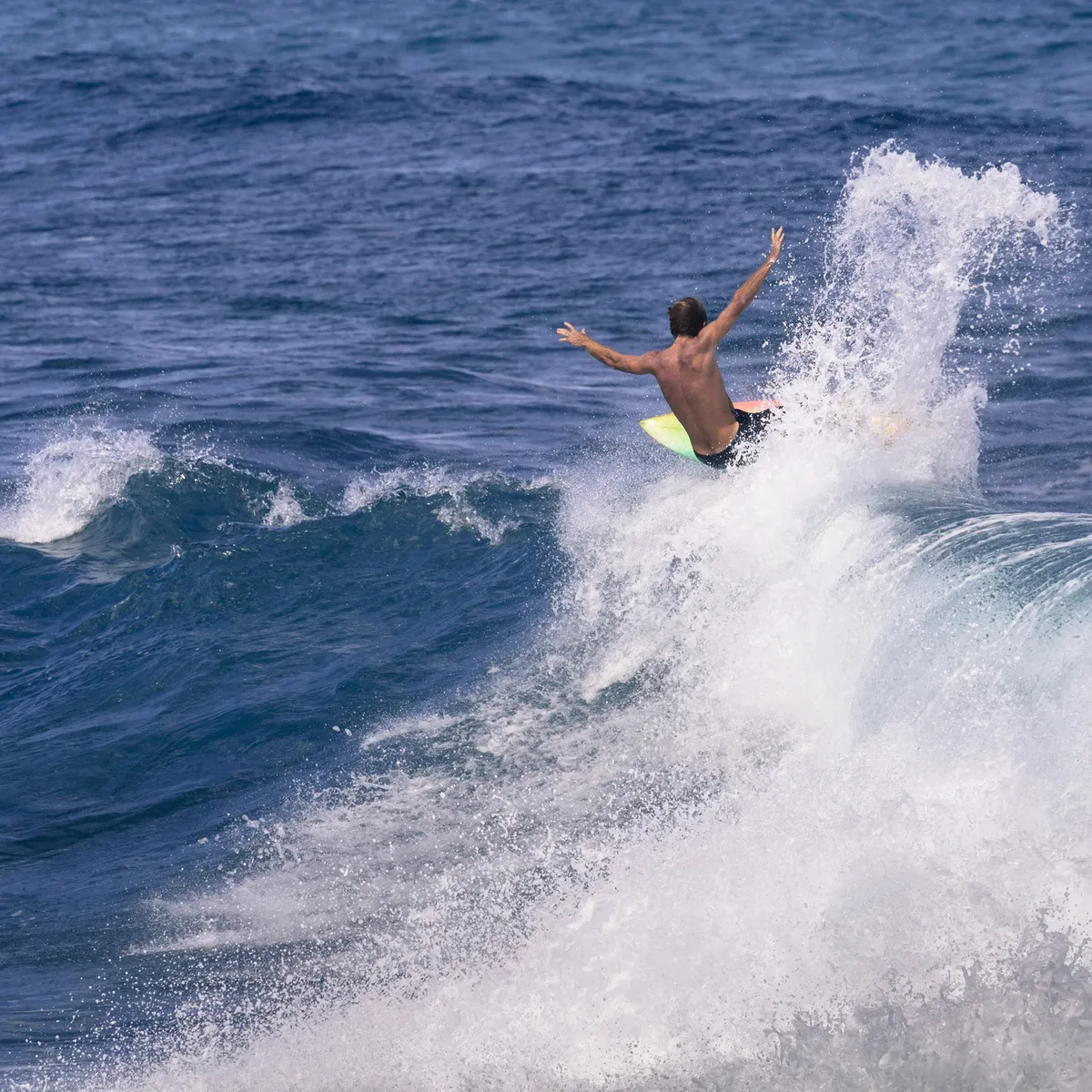 Honoli'i Beach Park's beautiful coastline with surfers in the water