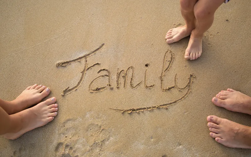 Family snorkeling in crystal clear Hawaiian waters with colorful tropical fish and coral - parents teaching children underwater exploration