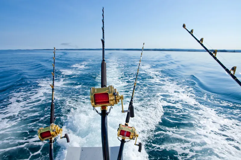Modern fishing charter boat with happy family holding their catch at Hawaiian harbor
