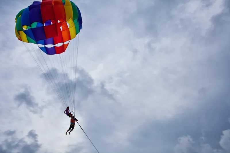 Split comparison showing views from different parasailing heights - 500ft vs 1,000ft vs 1,200ft over Hawaiian waters