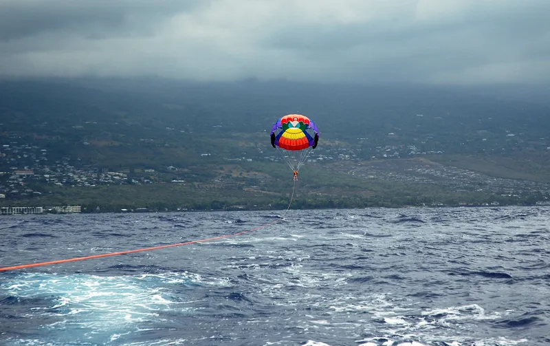 Professional captain checking weather instruments and conditions before parasailing departure in Hawaii