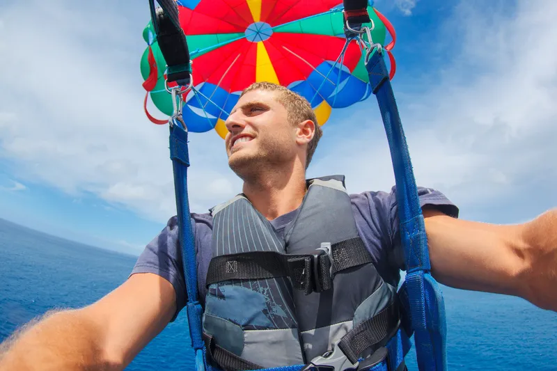 Historical timeline showing evolution from military parachute training to modern recreational parasailing in Hawaii