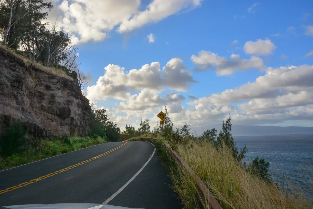 Winding Road to Hana with coastal cliffs and warning signs