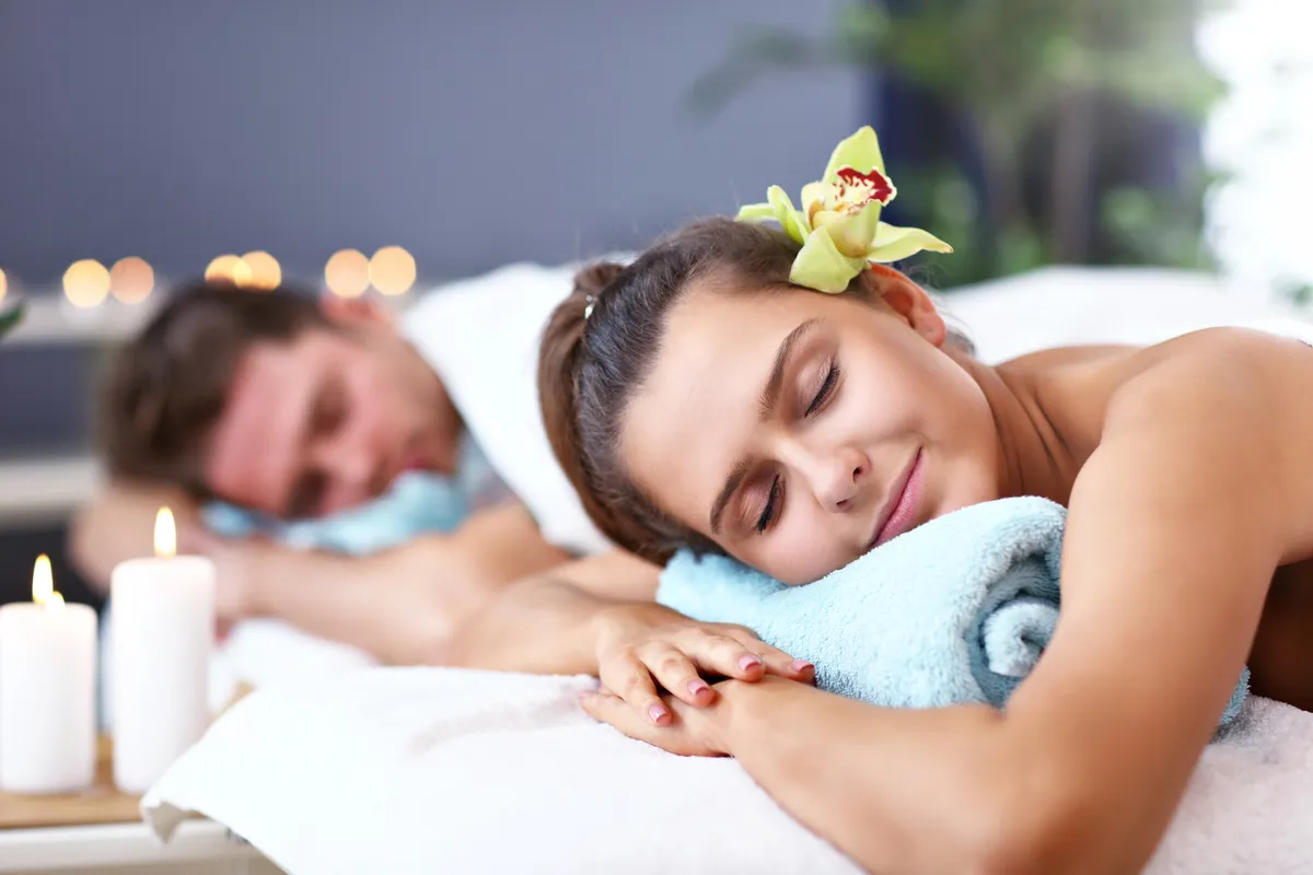 Romantic couples spa treatment with orchids and candles in serene setting