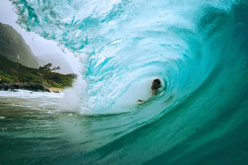 Split view showing gentle Waikiki waves on left and massive Pipeline wave on right - showcasing Oahu's range