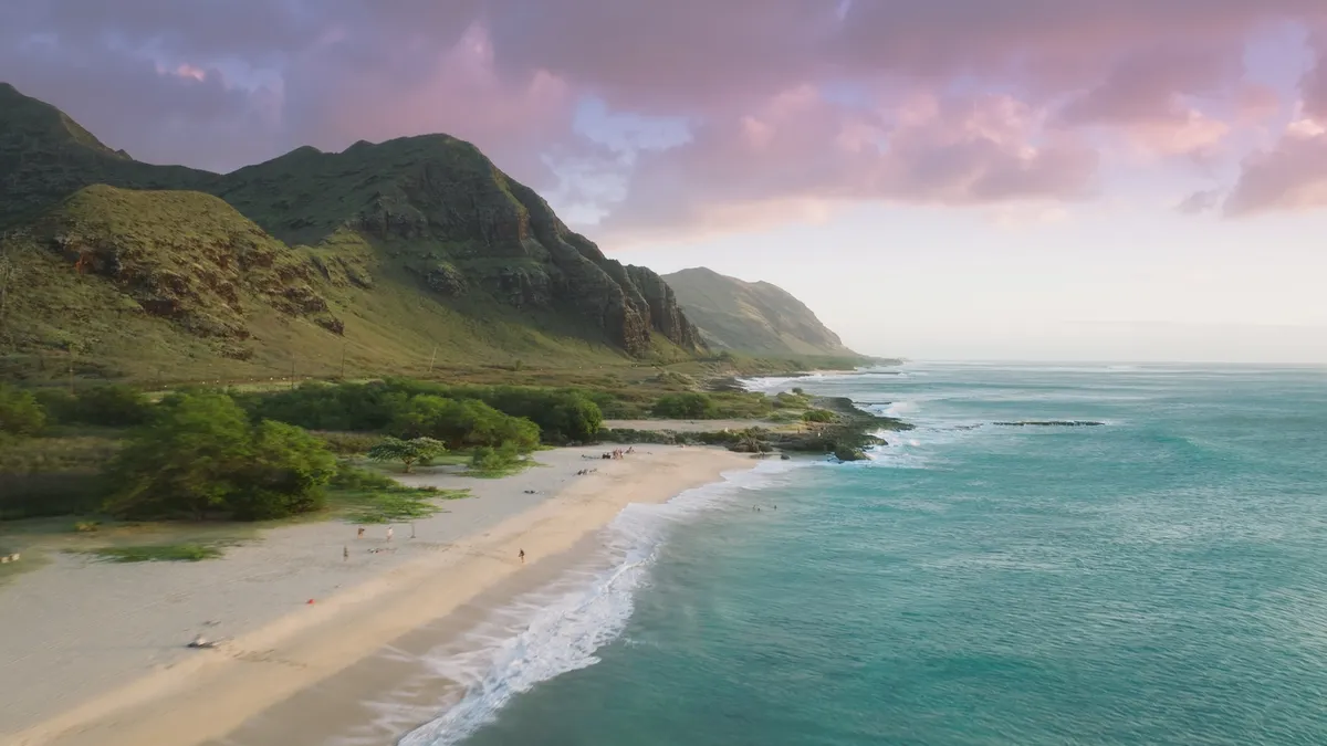 Makua Beach at sunset, Oahu - drone flying above cinematic ocean beach aerial view