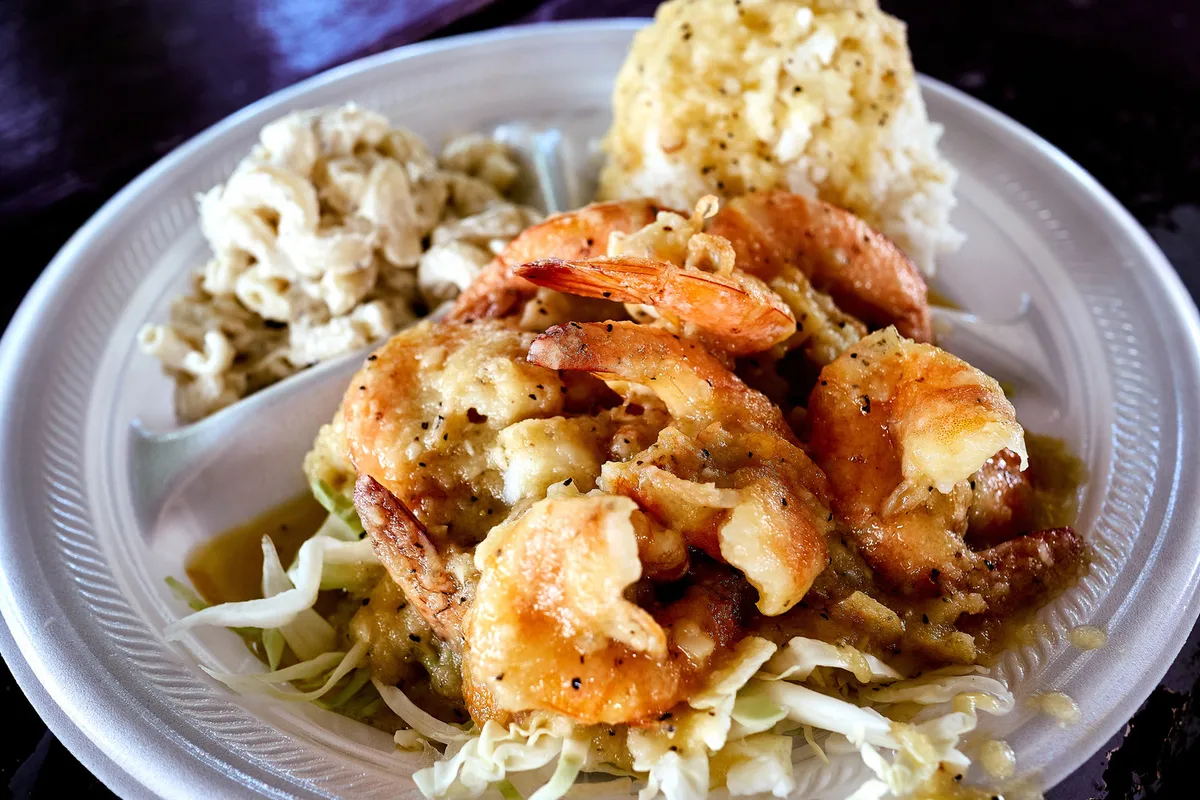 Classic Hawaiian plate lunch with grilled shrimp, rice, and mac salad showcasing plantation-era fusion