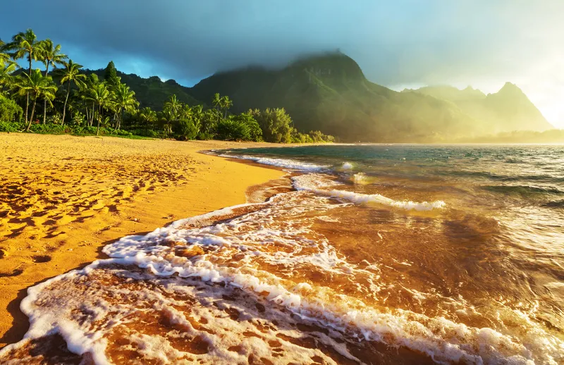 Stunning view of Tunnels Beach on Kauai showing the dramatic Na Pali coastline and crystal clear waters
